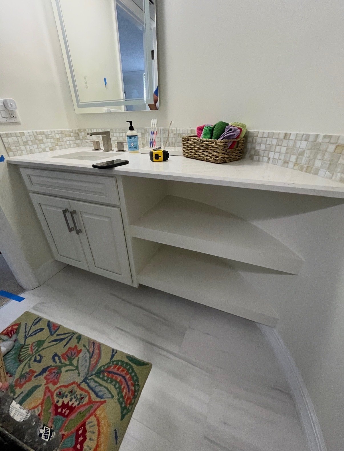 Custom bathroom vanity with floating shelves and tile backsplash