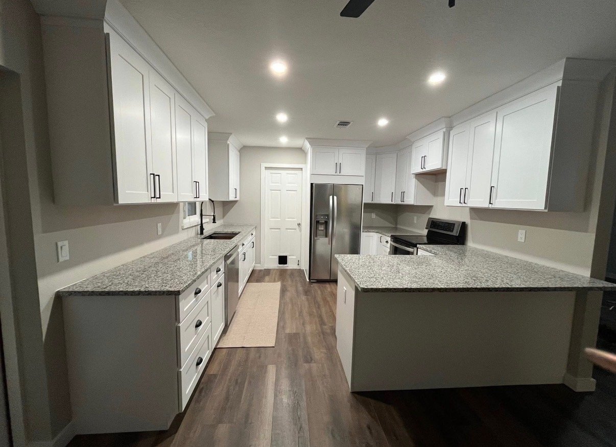 Galley kitchen remodel with white cabinetry and granite counters